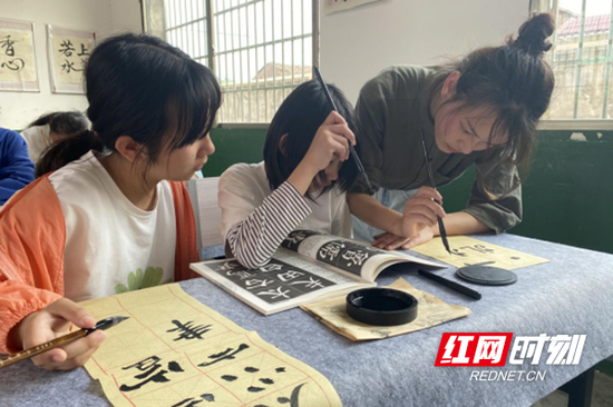 谭世婷在指导学生练习书法。