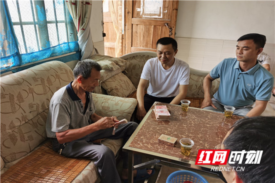 何某兵高兴地数着被退还的强制捐款。