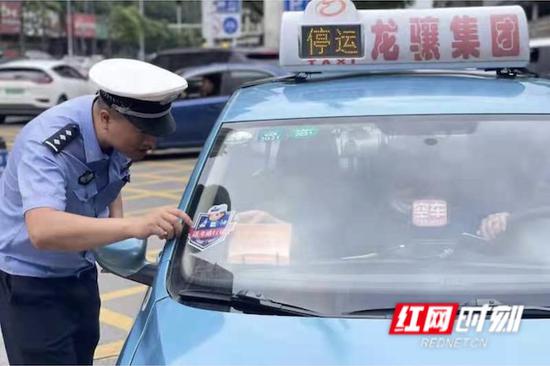 交警正在发放“送考通行证”。