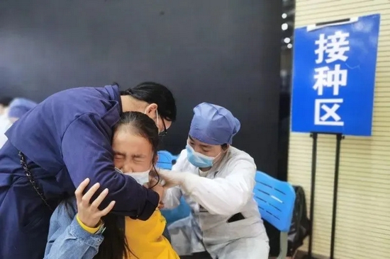 一名孩子在家人的陪同下勇敢接种疫苗。