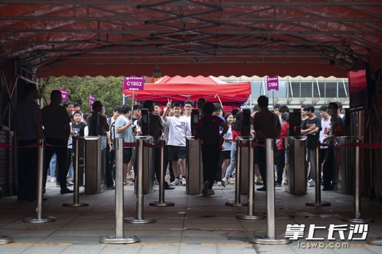 即将散考,一位考生隔着校门向接考的家长打招呼。长沙晚报全媒体记者 郭雨滴 摄