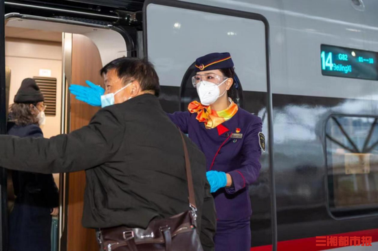 (高铁列车长为旅客提供咨询服务。陈俊彦 摄)