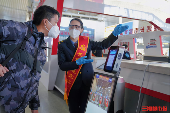 (旅客在长沙南站设置的自助机器人上查询信息。通讯员 供图)