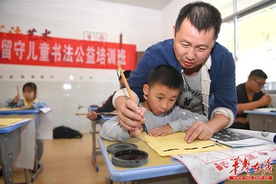 安化县沙田溪村,书法家们每周的公益书法课,助孩子们传承“字圣”笔墨。