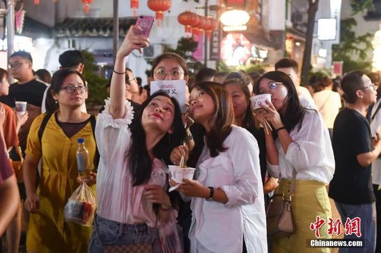 游人手捧长沙小吃合影