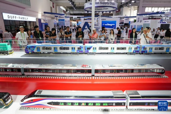 参观者在先进制造链展区中国中车展台参观展出的列车产品模型(7月16日摄)。图片来源:新华社