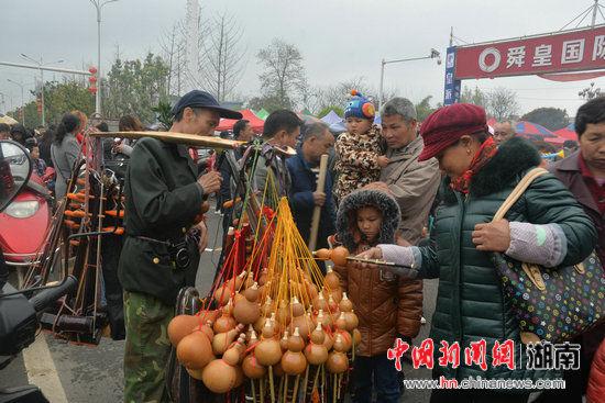 参加赶“春社”的民众正在挑选葫芦丝。