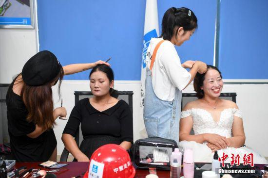 化妆师为女工人们化妆。 杨华峰 摄