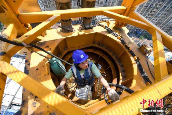 结束拍摄的塔吊驾驶员刘萍爬上塔吊作业。 杨华峰 摄