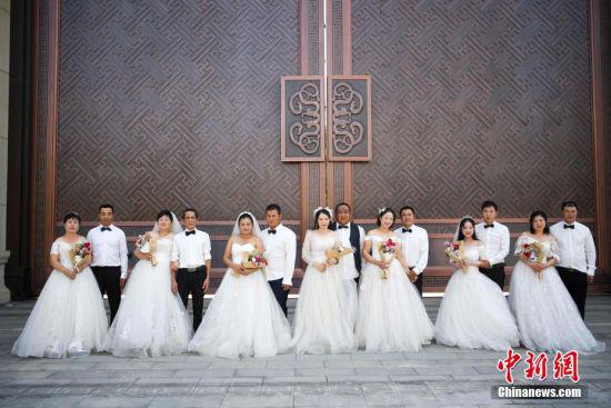 8月24日，长沙岳麓区的一建筑工地上，中建二局为该工地上的7对工人夫妻免费拍婚纱照。工人们身着婚纱与西服在园林与工地外取景拍摄，迎接七夕节的到来。杨华峰 摄