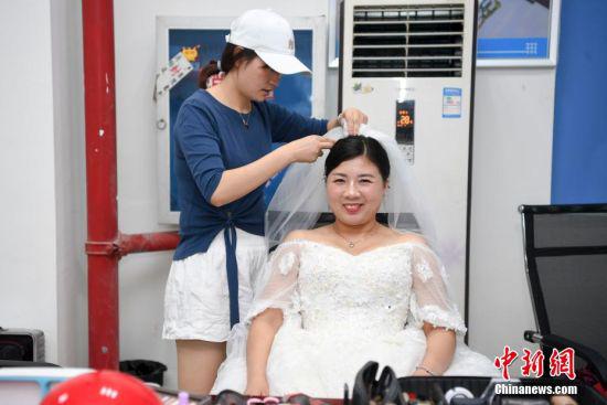 塔吊驾驶员刘萍戴上头纱笑得合不拢嘴。 杨华峰 摄