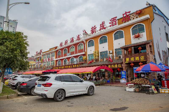 ▲鹤龙湖镇的美食街，省内外自驾游客纷至沓来，大过“蟹瘾”。