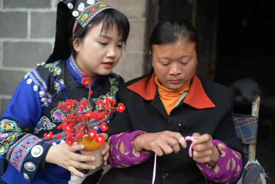 85 后女生谭艳林（左）教残障人士编织手工艺品