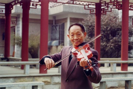 袁隆平在自家小院拉小提琴。湖南杂交水稻研究中心供图