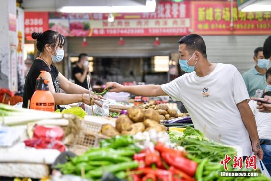 市民在张家界一菜市场购买蔬菜。 邵颖 摄