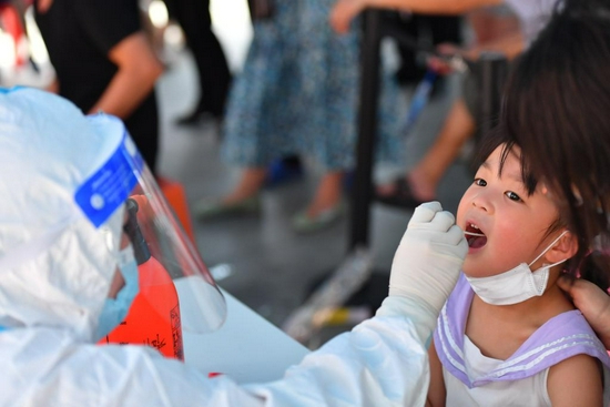  7月31日，在长沙市天心区赤岭路街道白沙花园社区核酸检测点，一名小朋友在接受核酸检测取样。新华社记者 陈泽国 摄
