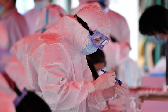 7月29日，在张家界市永定区崇实南校核酸检测点，医务人员正在标记核酸检测取样标本。新华社发（向韬摄）