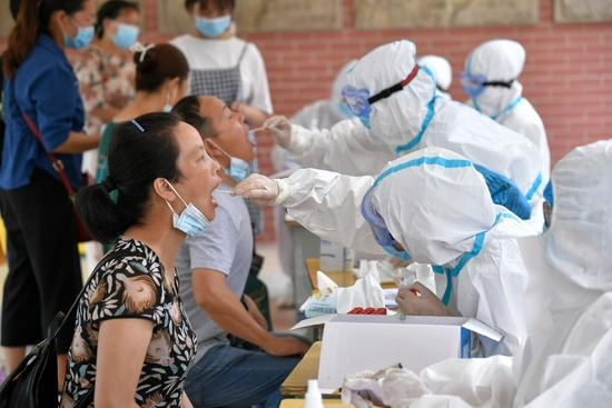 7月29日，在张家界市永定区崇实南校核酸检测点，市民正在有序接受核酸检测取样。新华社发（向韬摄）