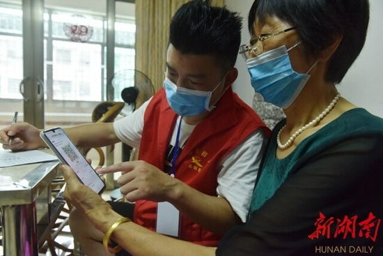 　(8月9日，衡东县洣水镇新世纪市场，新冠疫苗接种宣传分队上门核查居民健康码、行程码和疫苗接种情况。肖亚辉 周健 摄)
