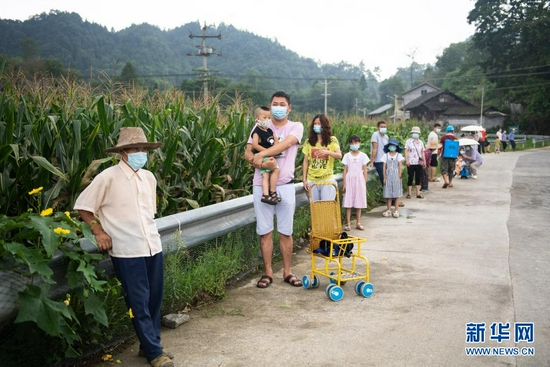 8月12日，在张家界市永定区沅古坪镇柏杨坪村，村民排队等待做核酸检测