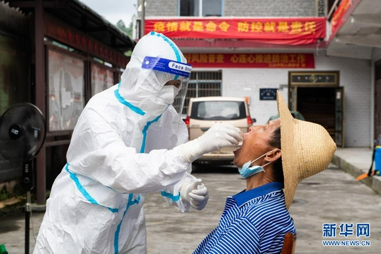 8月12日，在张家界市永定区沅古坪镇柏杨坪村，医务人员给村民做核酸检测取样