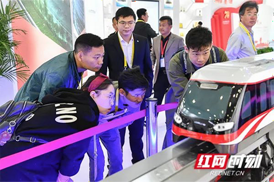 2019年“轨博会”现场,工作人员向参观者介绍磁浮快线列车