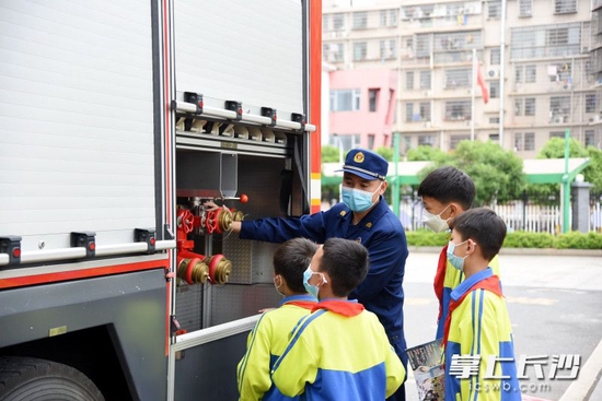  消防员为四名少年讲解消防车上的设施和装备。长沙晚报全媒体记者 刘琦 摄
