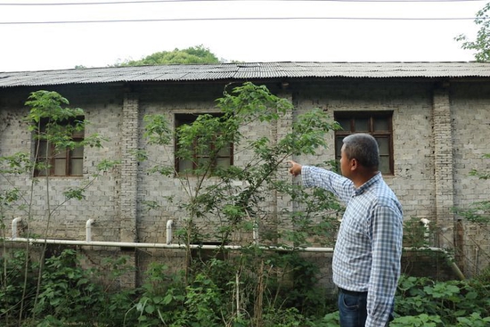 欧阳鹏在介绍一处即将被拆除的猪舍（4月24日摄）。新华社记者 丁春雨 摄