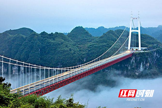 远远望去，矮寨大桥如一道彩虹，拔地通天，在崇山峻岭之间牵起一方胜境。