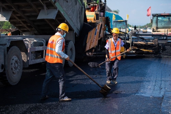 7月27日，工人在平益高速建设现场进行沥青上面层摊铺施工。新华社记者陈思汗摄