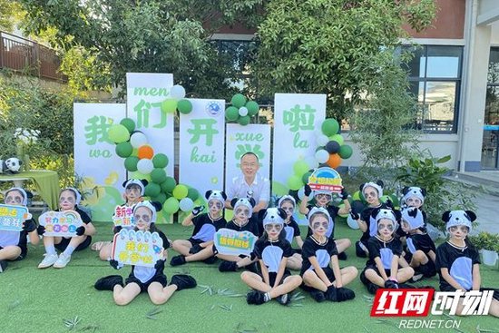 一群由小学生扮演的萌宝大熊猫在校门口迎接新生。(图片来源:红网时刻)