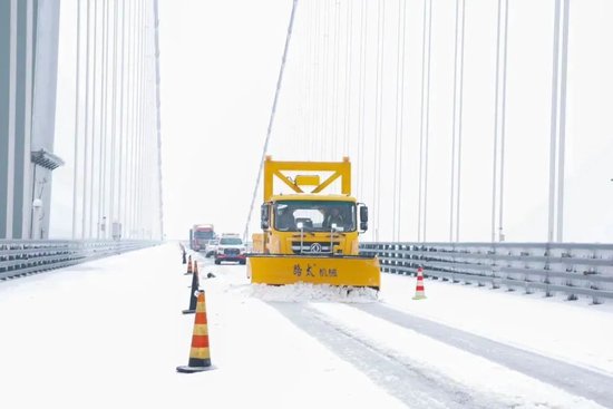 工作人员在杭瑞高速公路洞庭大桥开展除雪作业。