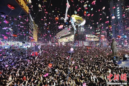 游人在长沙黄兴路倒数跨年,放飞气球迎接2024年的到来