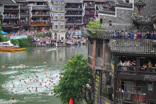 凤凰古城沱江上热闹非凡,市民和游客进行抢鸭子比拼