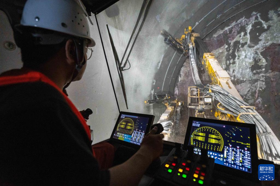 11月1日，在邵永高铁东安隧道施工现场，中铁二十五局工人操作三臂凿岩台车进行钻孔作业。