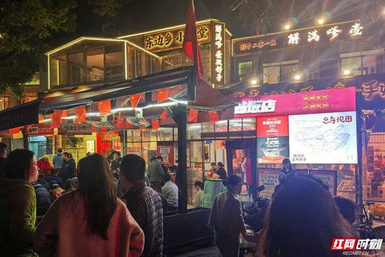  “壹双好手口味饭店”门口，顾客正在排队。