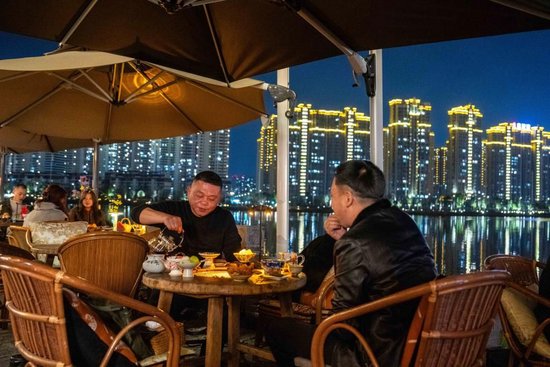 3月11日，游客在穿紫河畔的常德河街品茶。新华社记者 陈思汗 摄