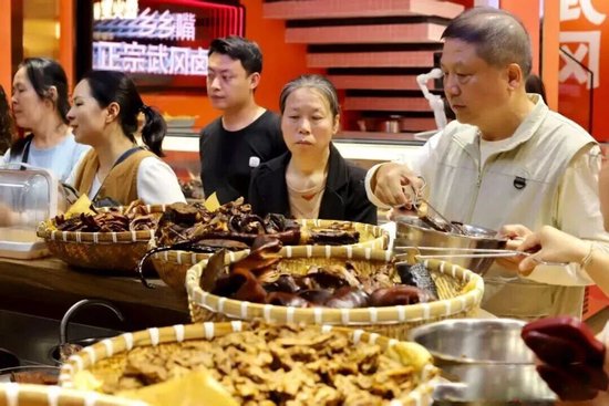 在乡乡嘴卤味体验馆，游客挑选卤豆腐、卤铜鹅等产品