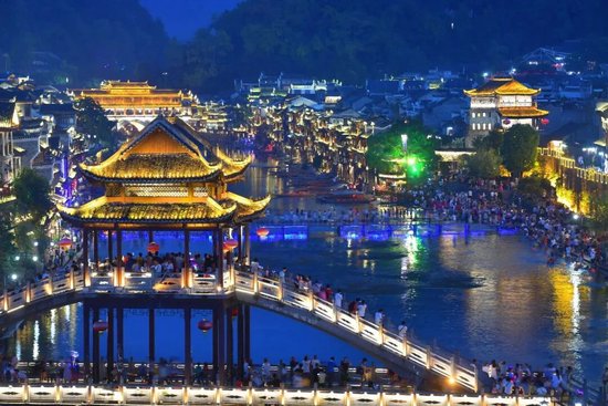 游客在沱江边赏景纳凉。图/郭立亮
