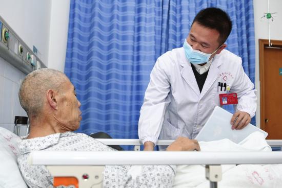 2 月 8 日,湖南省第二人民病院,何改生正在和患者交流。图 / 记者谢长贵