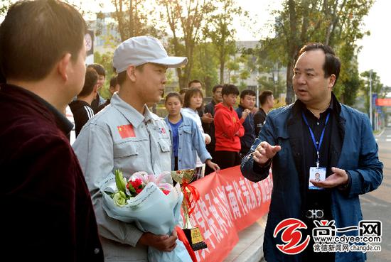 常德技师学院党委书记毛泽陆（右）欢迎陈涛载誉归来。常德技师学院供图