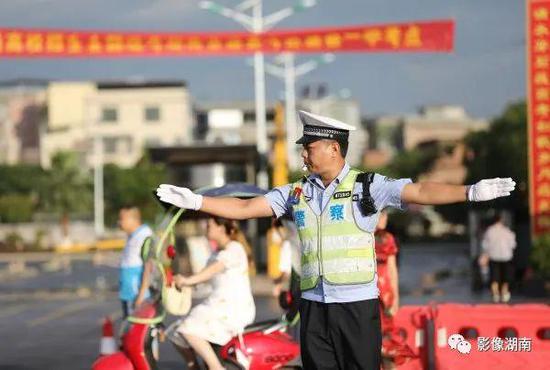  道县第一中学考点门口，交警在指挥路面交通。该县今年共有4427名考生参加高考，设3个考点，170间考室。何红福 摄