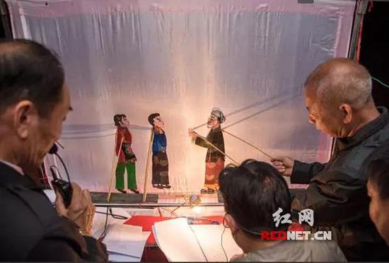 ▲皮影人在幕后双手舞动百万兵。图片来源:红网