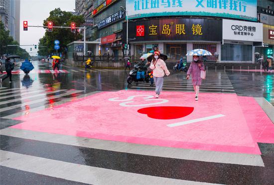 长沙解放西路与黄兴路交汇处粉色斑马线的颜色变成粉、白相间，中间印着“心形”图案。摄影/彭福宗