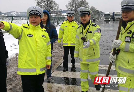 省公安厅副厅长汤向荣（左一）带领交警来到结冰路段引导交通秩序。