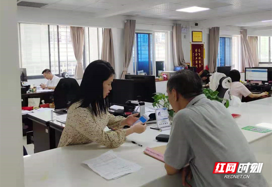 柜面工作人员现场为职工帮办网厅业务。