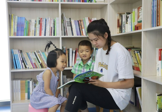 2021年9月17日，向树芬（右一）在湘西土家族苗族自治州慈爱园与小朋友一起读书。受访者供图