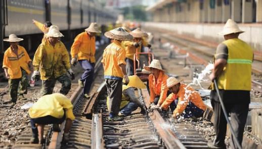 　　6月27日，长沙火车站，广铁长沙工务段工人在烈日下更换长轨施工。当天，长沙高温持续，最高气温达36℃。该工务段的70余名工作人员需在15时至18时的施工天窗期内对约1100米的轨道进行更换，确保火车行车安全。   傅聪 郭威 摄影报道 