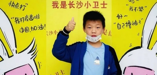 “我是长沙小卫士，我为自己点赞。”砂子塘小学的孩子们在学校宣传画前为自己点赞。