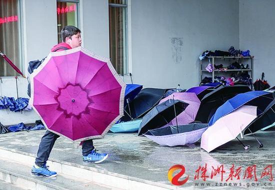 昨日，阴雨不断，气温降低。在湖南工业大学图书馆侧门，摆满了雨伞